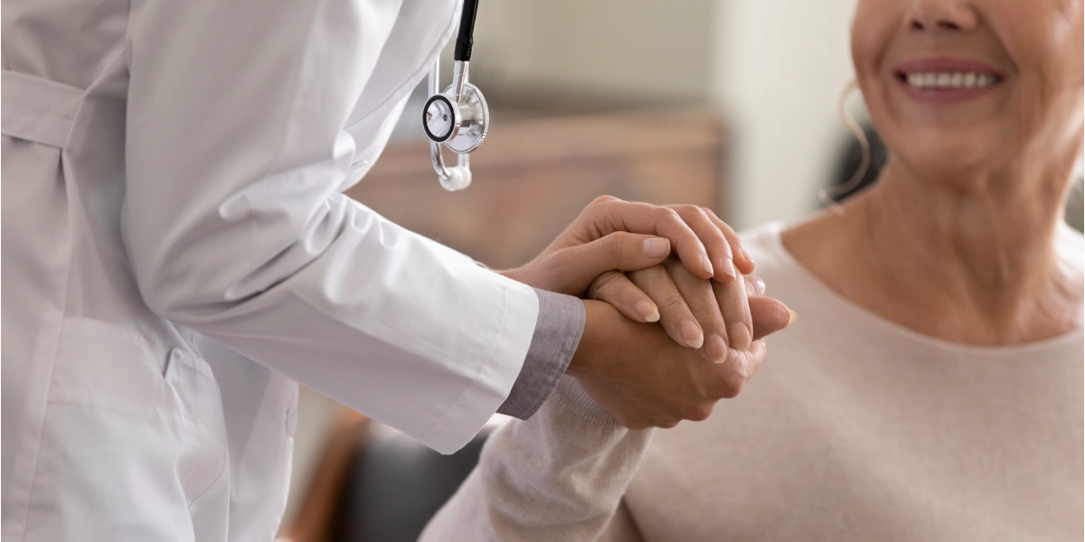 A nurse holding the hand of a woman