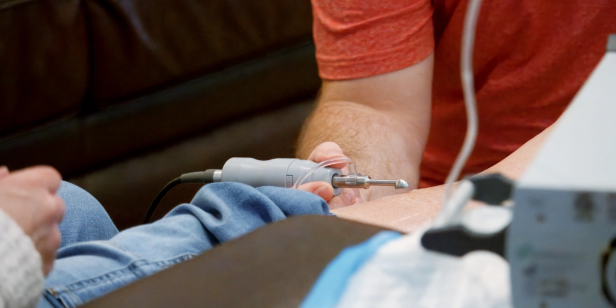 Clinician applying non-contact ultrasound mist therapy to a chronic wound