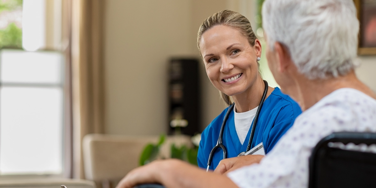 A female nurse talking to an elderly patient